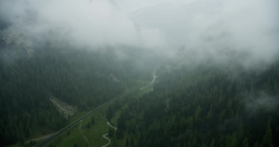 Aerial panorama of mountains with greenish forests on a foggy day