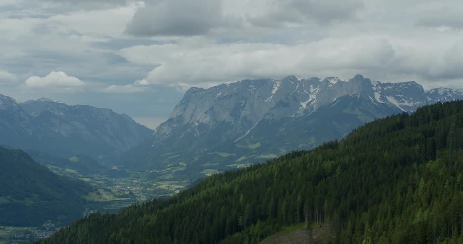 A rural community sits in a valley surrounded by giant mountains