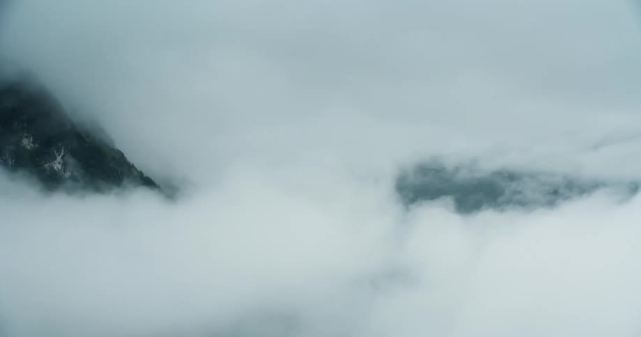 A mountain and valley almost entirely shrouded in thick clouds