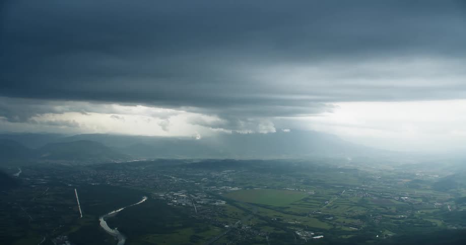 Aerial panorama of an urban city built on hills with surrounding mountains on a cloudy day