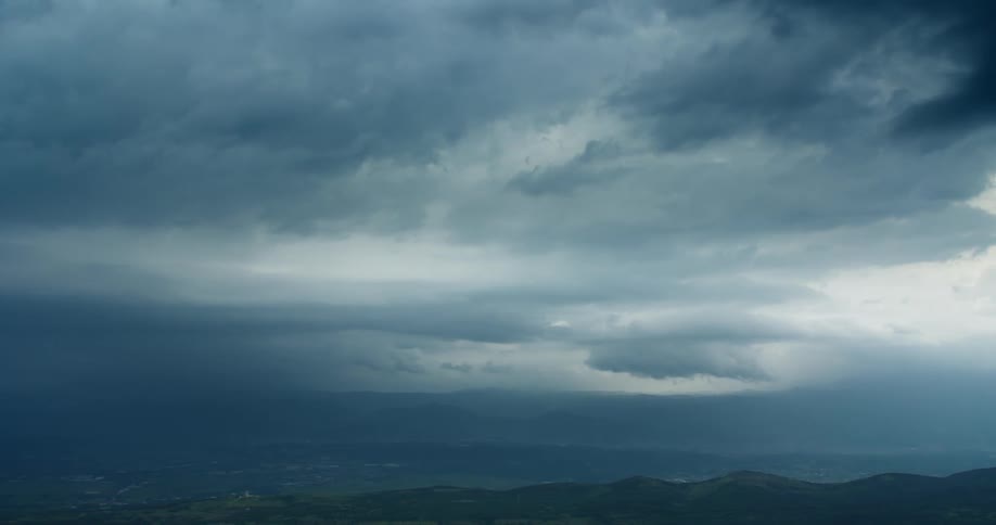 Aerial landscape of greenish mountains over a cloudy sky