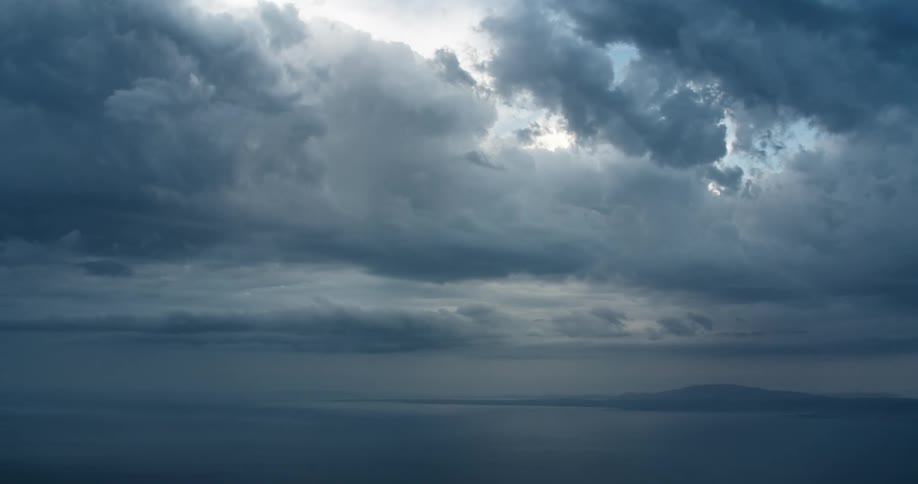 An aerial view of a horizon and many white clouds passing in the sky