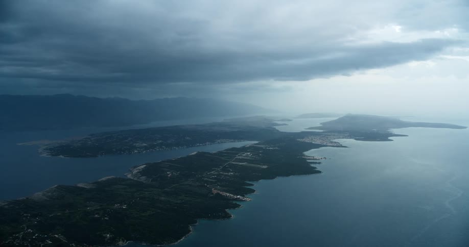 Aerial view of a coastal landscape with a peninsula under overcast skies