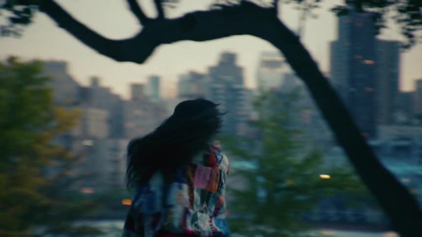 A young woman listening to music and dancing outside sliding as if on rollerskates