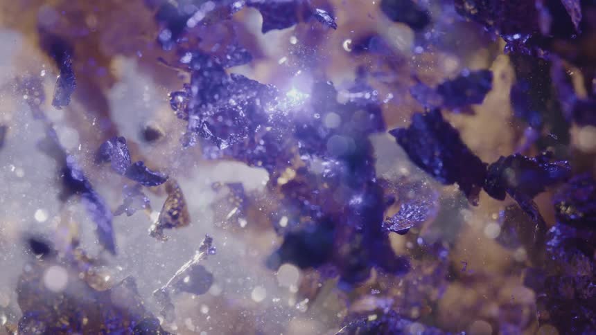 Extreme closeup on a liquid with abstract glowing particles