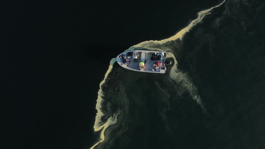 Boat with three people stopped in the middle of the ocean