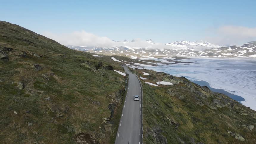 Two cars drive down the mountain road