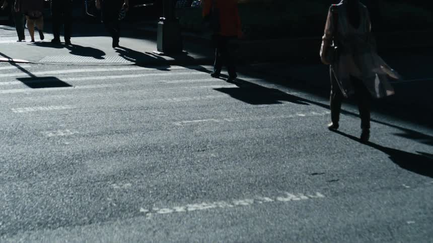 A vibrant cityscape with pedestrians leisurely walking along a bustling street