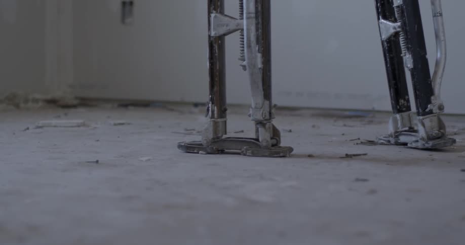 A person walks on stilts in a room