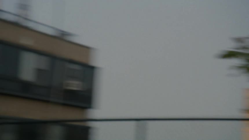 A woman passes by the building earing earbuds