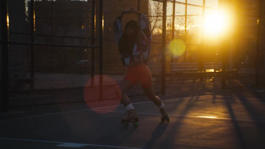 A woman rollerskates at sunset