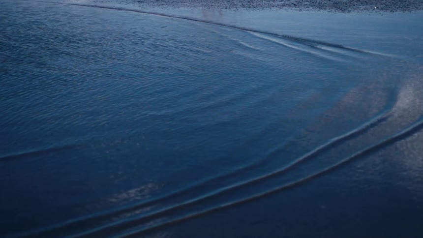 Small bubbles on the surface of water going to the right