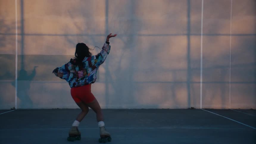 Young woman roller skating and dancing