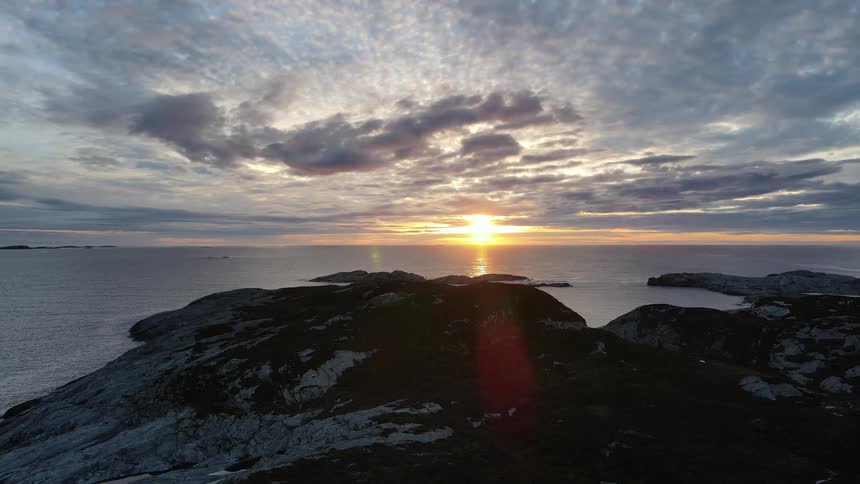 Landscape of a rocky seaside coast with sunrise on the horizon