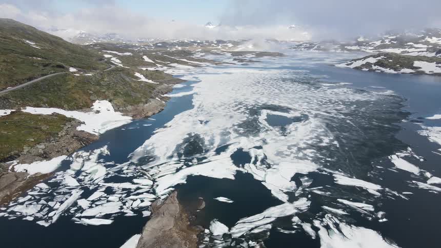 Ice covers some of the river by the mountains