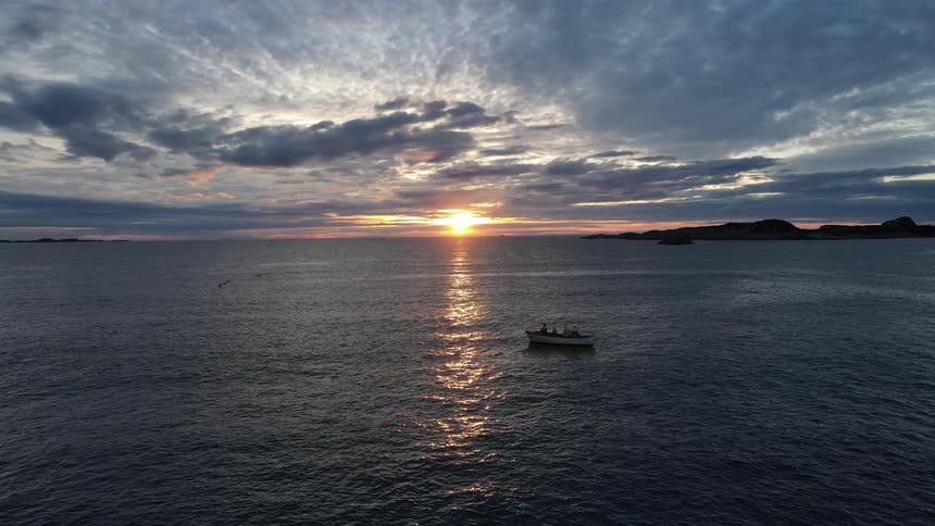 A boat on the water at sunset under a cloudy sky