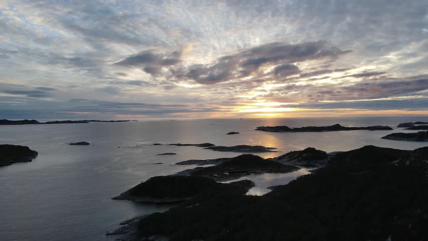 Natural landscape of rocky shores by the sea with the sun on the horizon