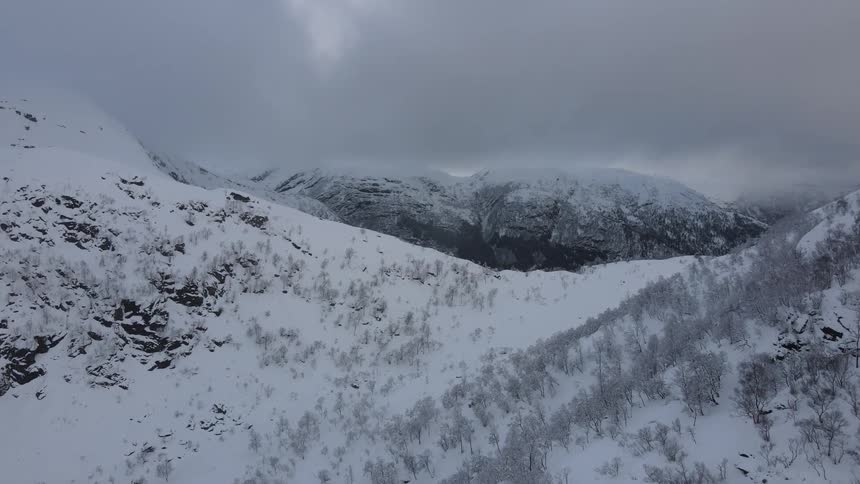 Aerial panorama of snowcovered mountain ranges on a cloudy day