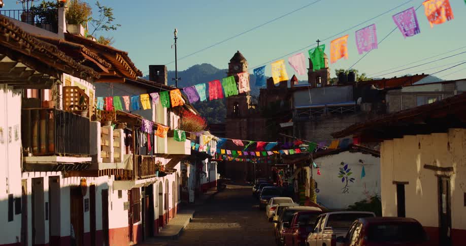 Alley of a residential neighborhood with colorful festival flags and parked cars