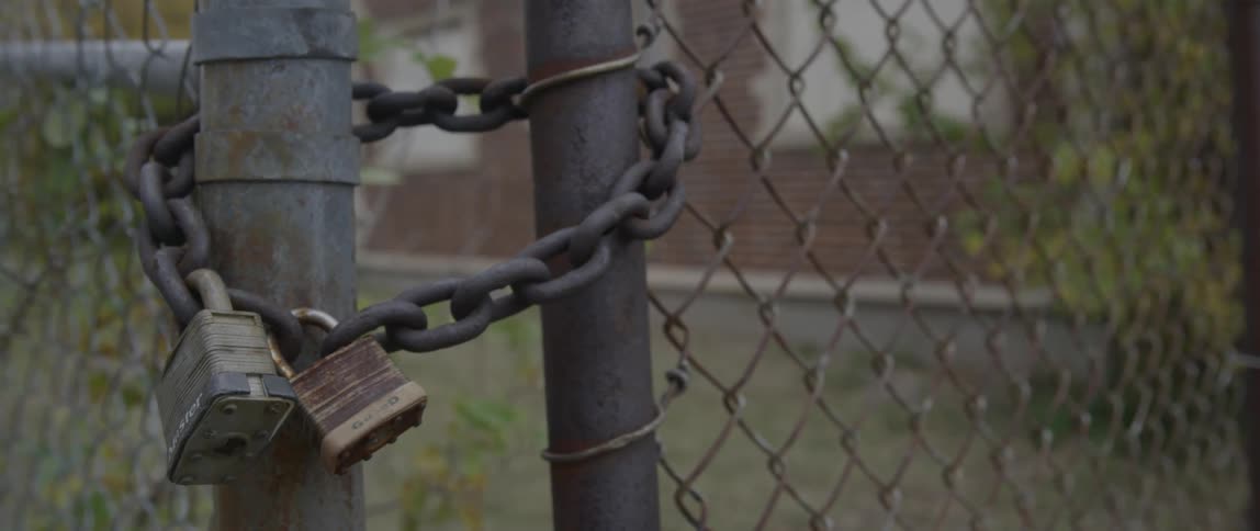 A view of a chain with two locks securing a gate