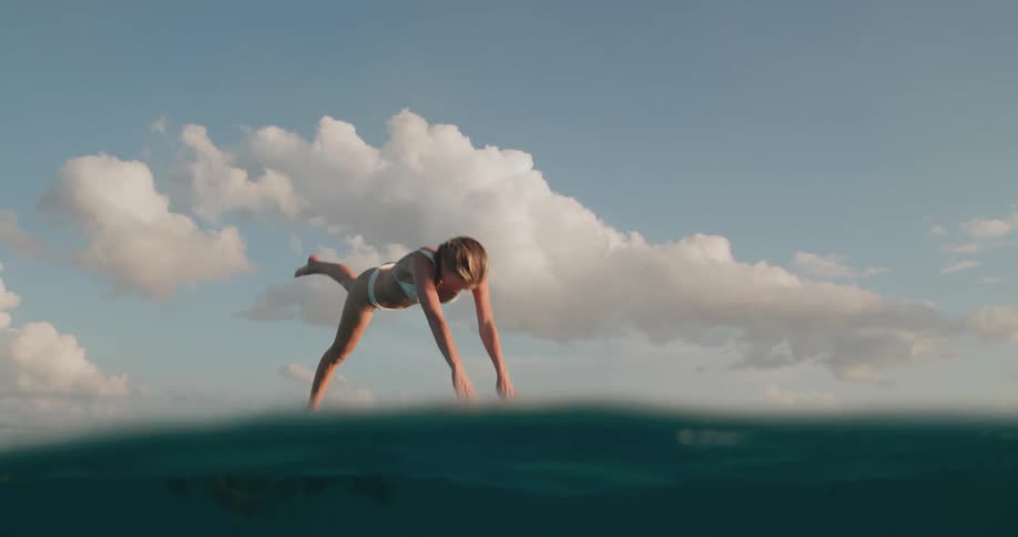 A woman takes a dip in sea water and blows several bubbles underwater