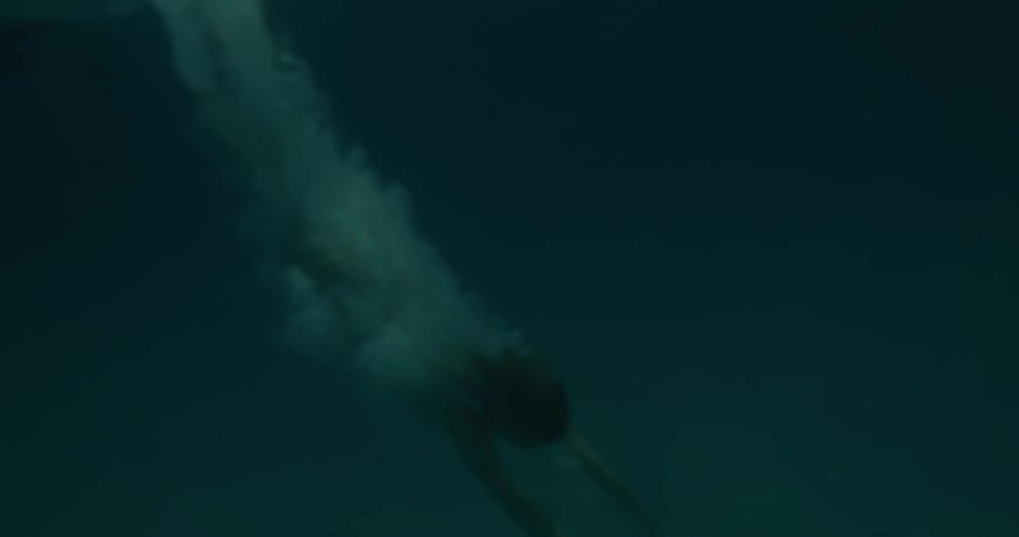 Woman in white bikini diving in the ocean