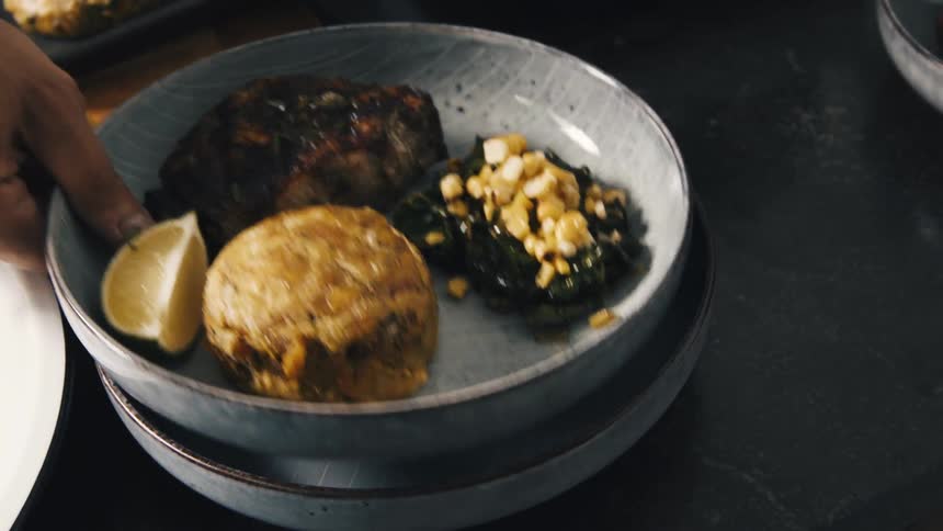 A person picks up a shallow bowl filled with food