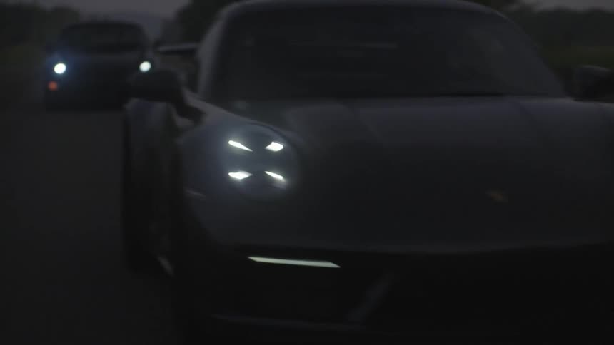 Sports car with led headlights on at dusk