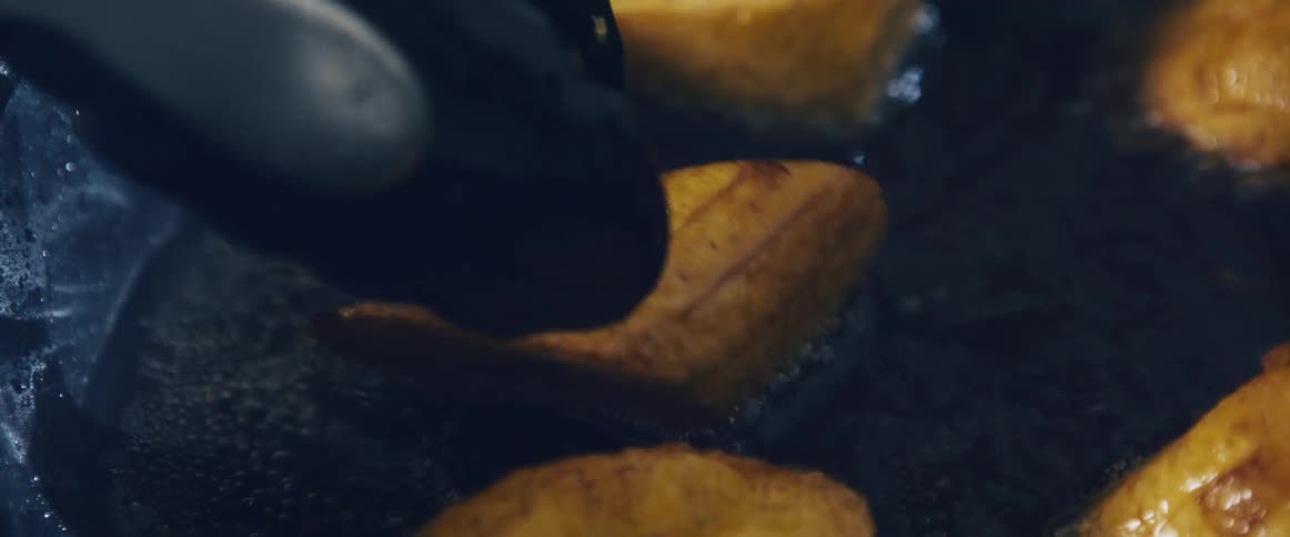 Plantain slices being fried in oil