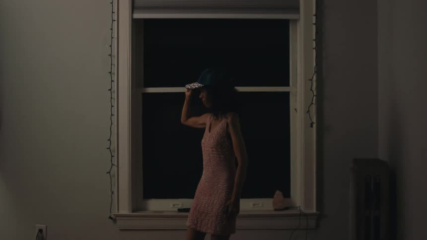Woman indoor trying on a shiny cap