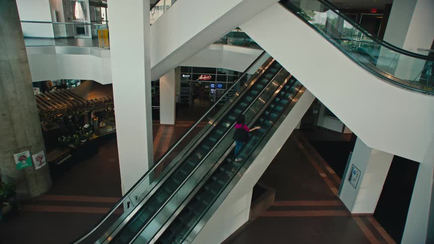 Woman climbing the escalator of a building
