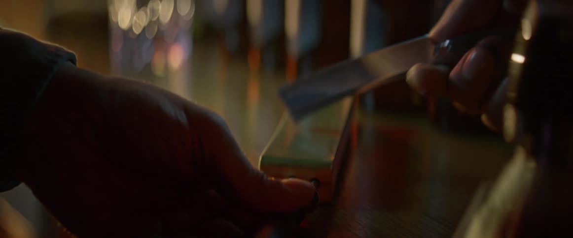 Closeup of a persons hands sharpening a razor