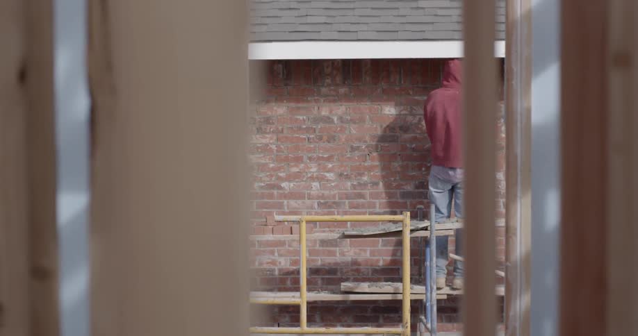 A man works on a brick structure