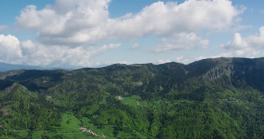Landscape of green mountains in a partly cloudy sky
