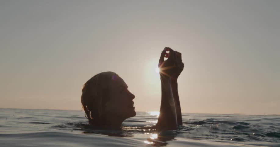 A woman smiles while floating in an ocean