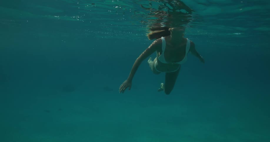 A woman in a bikini swims in the ocean