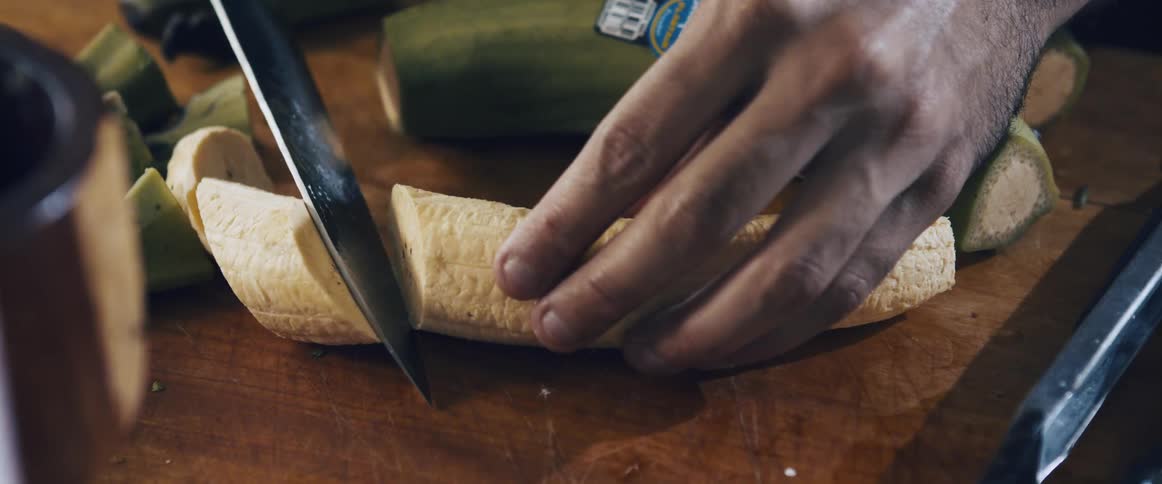 Plantain being cut on a wooden table
