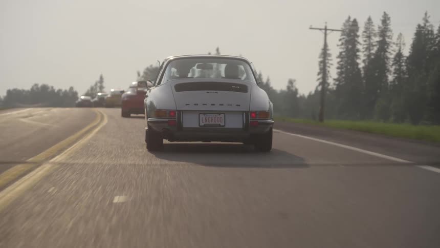 Back view of a porsche traveling along a highway