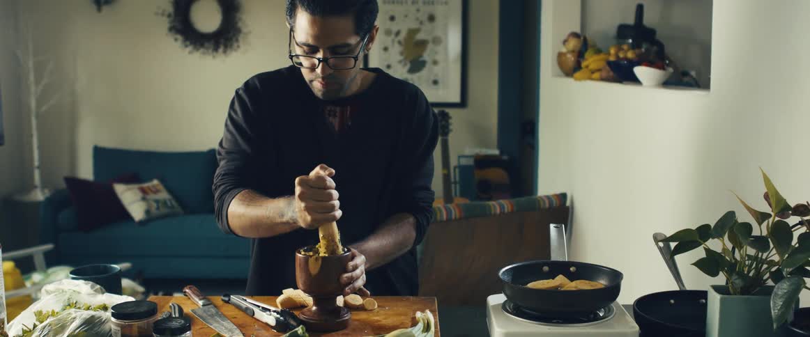 Man uses mortar and pestle while cooking in the kitchen at home