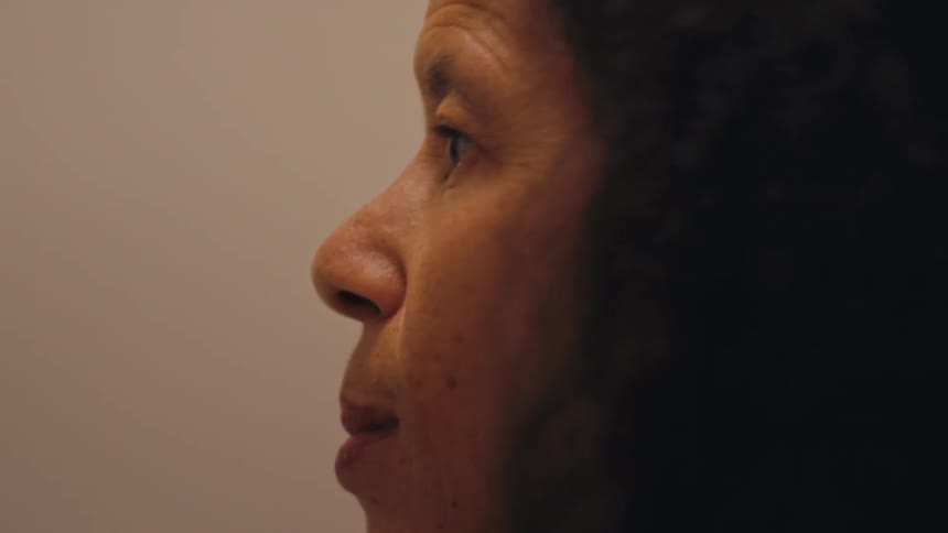 A person applying a makeup brush to the skin of their face
