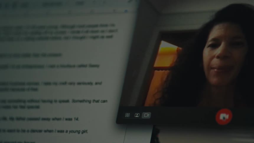 Woman sitting and her face appearing on a tablet screen