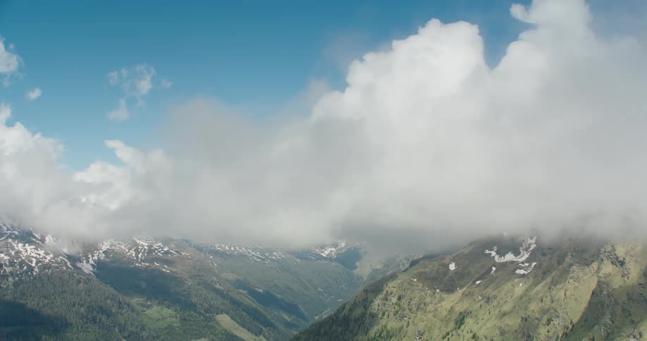 The clouds sit on the peaks of the mountains