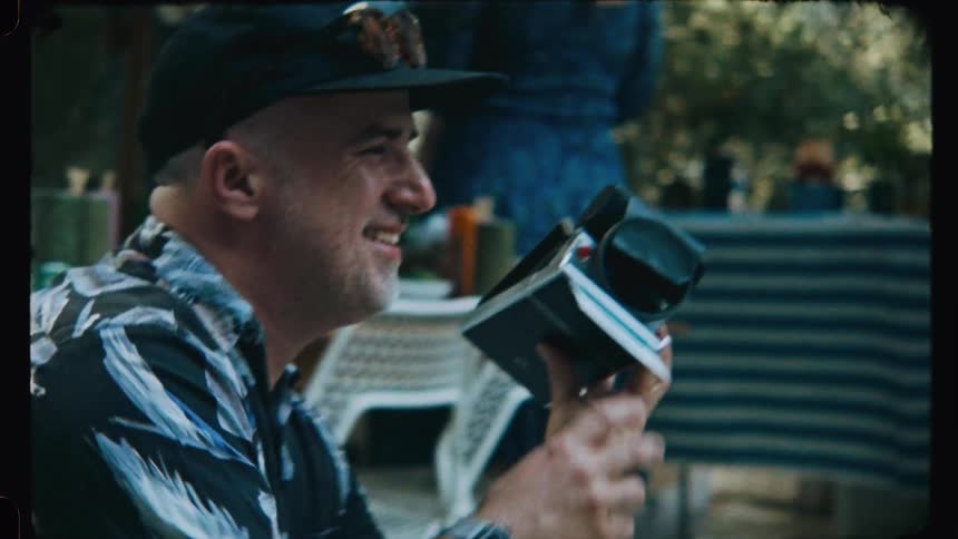 Smiling man photographing with a vintage camera