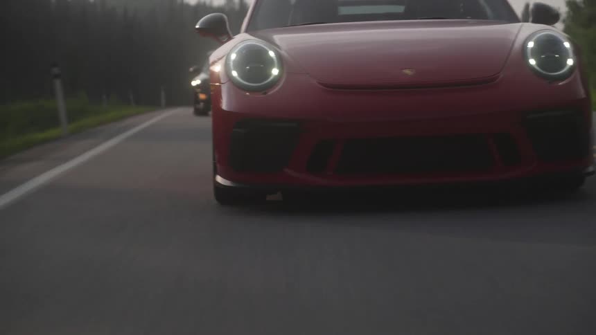 Sports cars on a highway traveling along a highway