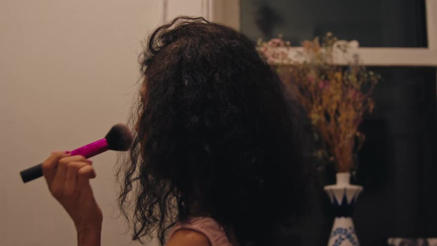 Woman putting on makeup with blush