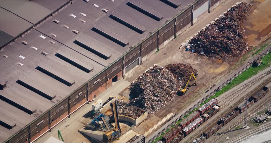Aerial panorama of a factory with landfill and construction machines next to it