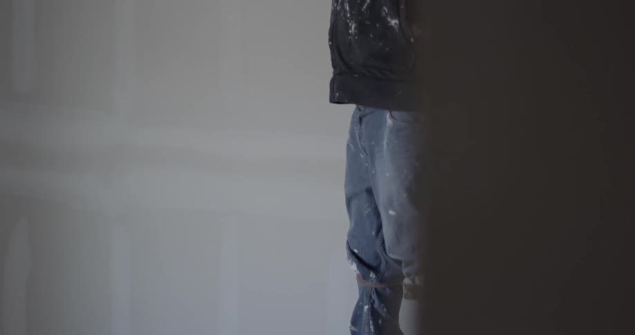 A man is walking on stilts while working on the ceiling
