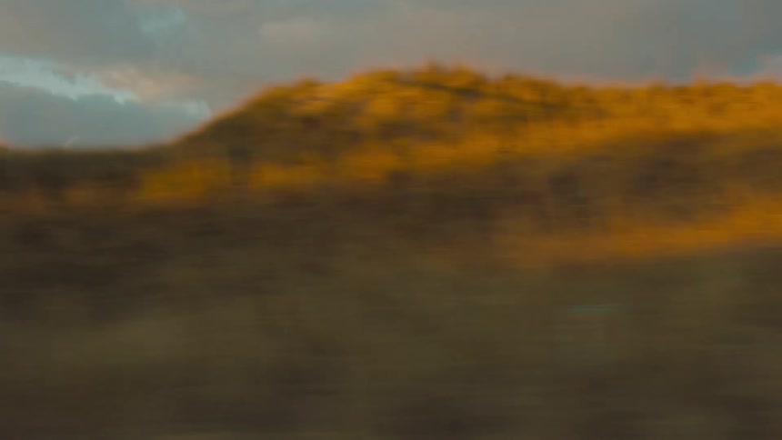 Rolling hills with golden grass illuminated by sunlight
