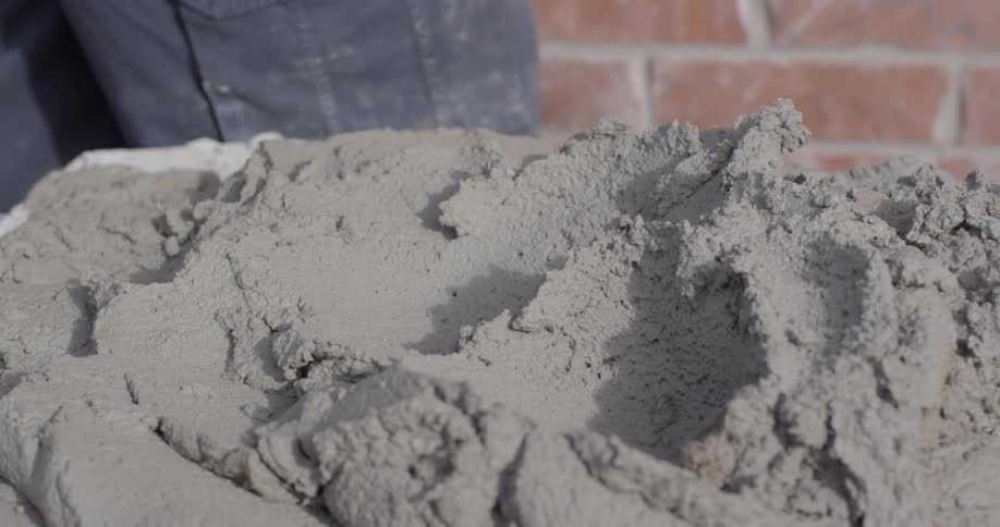 A man scoops clay from a pile