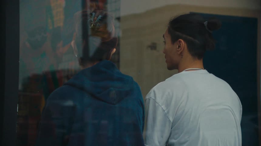 View from outside a window of a man and a woman sitting and talking